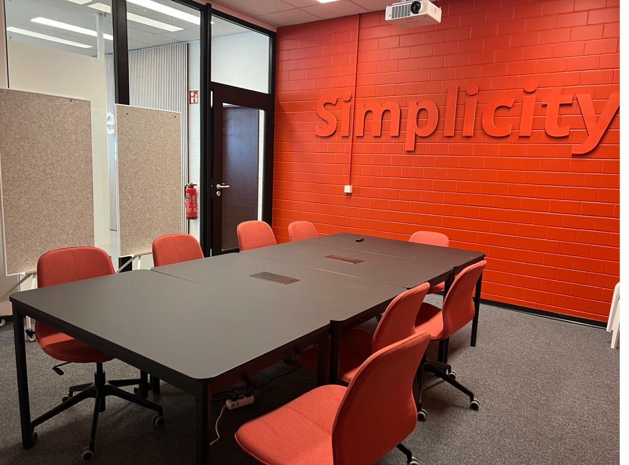 Weitwinkelansicht des Konferenzraums mit Simplicity-Motto