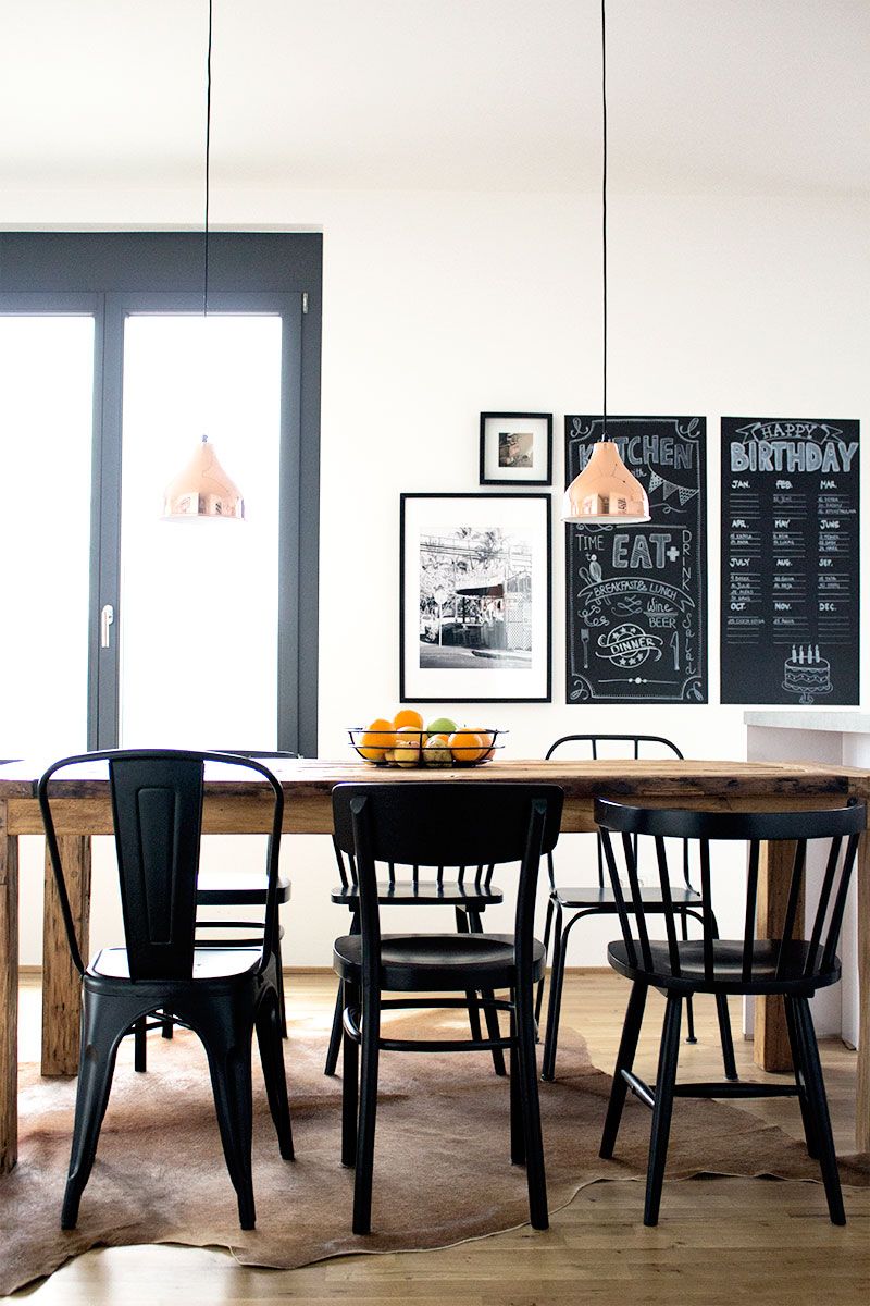 Essbereich der Neubauwohnung Berlin mit Kupferlampen und gemischten Stuhltypen am Holztisch