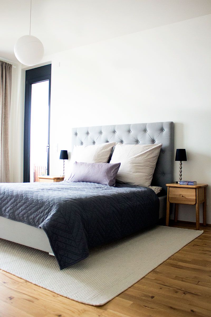 Schlafzimmer mit gepolstertem Kopfteil, sanfter Beleuchtung und reduzierter Einrichtung